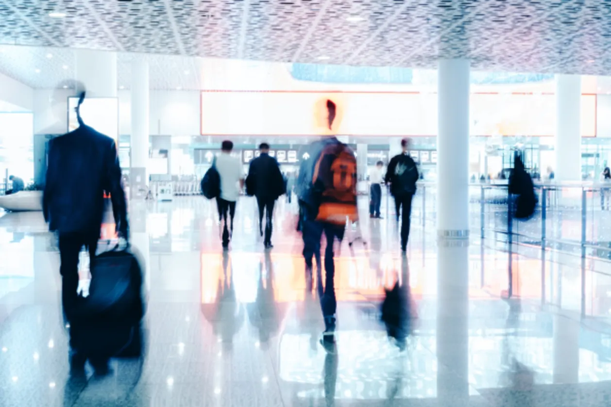 motion blurred travellers walking in modern airport hallway